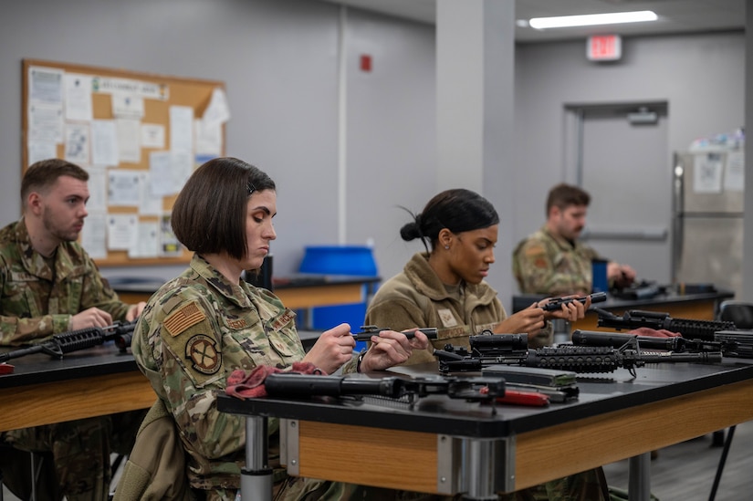 U.S. Air Force Staff Sgt. Audra Sensor, 633d Medical Group aerospace medical technician, (left), and Senior Airman Brittney Norwood, 633d MDG medic, disassemble the bolt carrier from their M-4 carbine rifles during their Combat Arms Training and Maintenance qualification course at Joint Base Langley-Eustis, Virginia, Nov. 30, 2022.