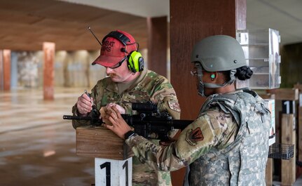 U.S. Air Force Staff Sgt. Michael Tack, 633d Security Forces Squadron combat arms instructor, makes iron-sight adjustments for an Airman during the practice rounds of the firing portion of the M-4 carbine rifle qualifications during a Combat Arms Training and Maintenance qualification course at Joint Base Langley-Eustis, Virginia, Nov. 30, 2022.