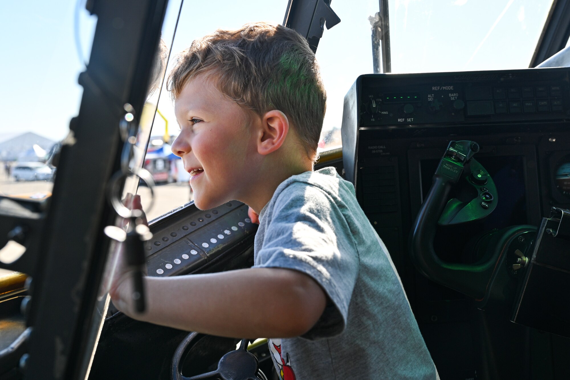 A child looks through a window inside of a C-130J.