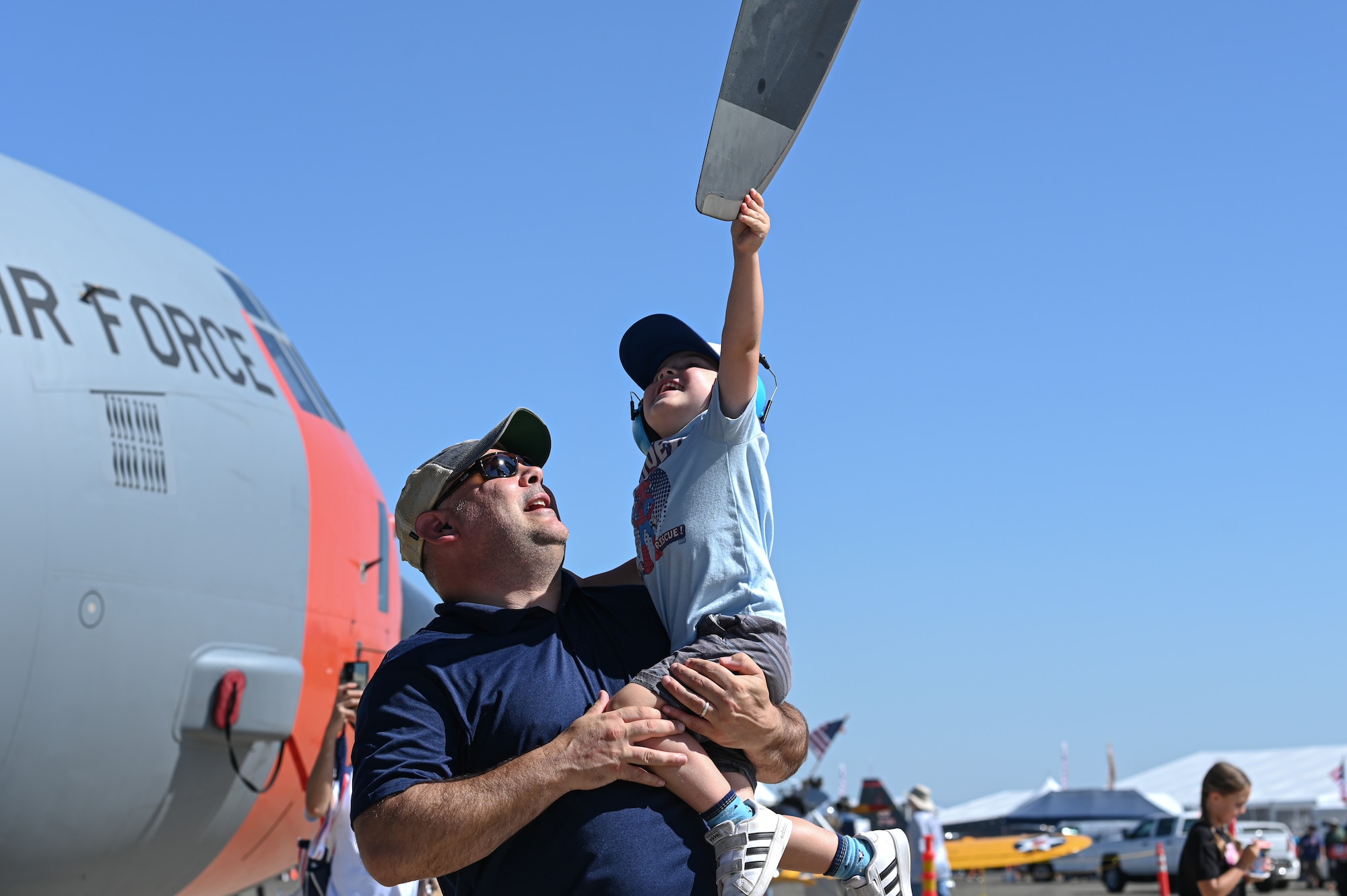 A father and son touches a C-130J propellor.