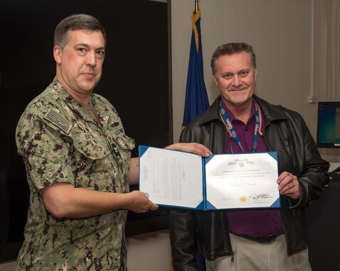 (left) Naval Surface Warfare Center Panama City Division Commanding Officer Capt. David Back presents Dennis Russell, NSWC PCD investigations director, with the Navy Civilian Service Commendation Medal, Nov. 28. Russell served as the NSWC PCD Command Review and Investigations Office director for 10 years, continually providing daily expertise essential to the success of the Navy and the Fleet. (U.S. Navy photo by Eddie Green)