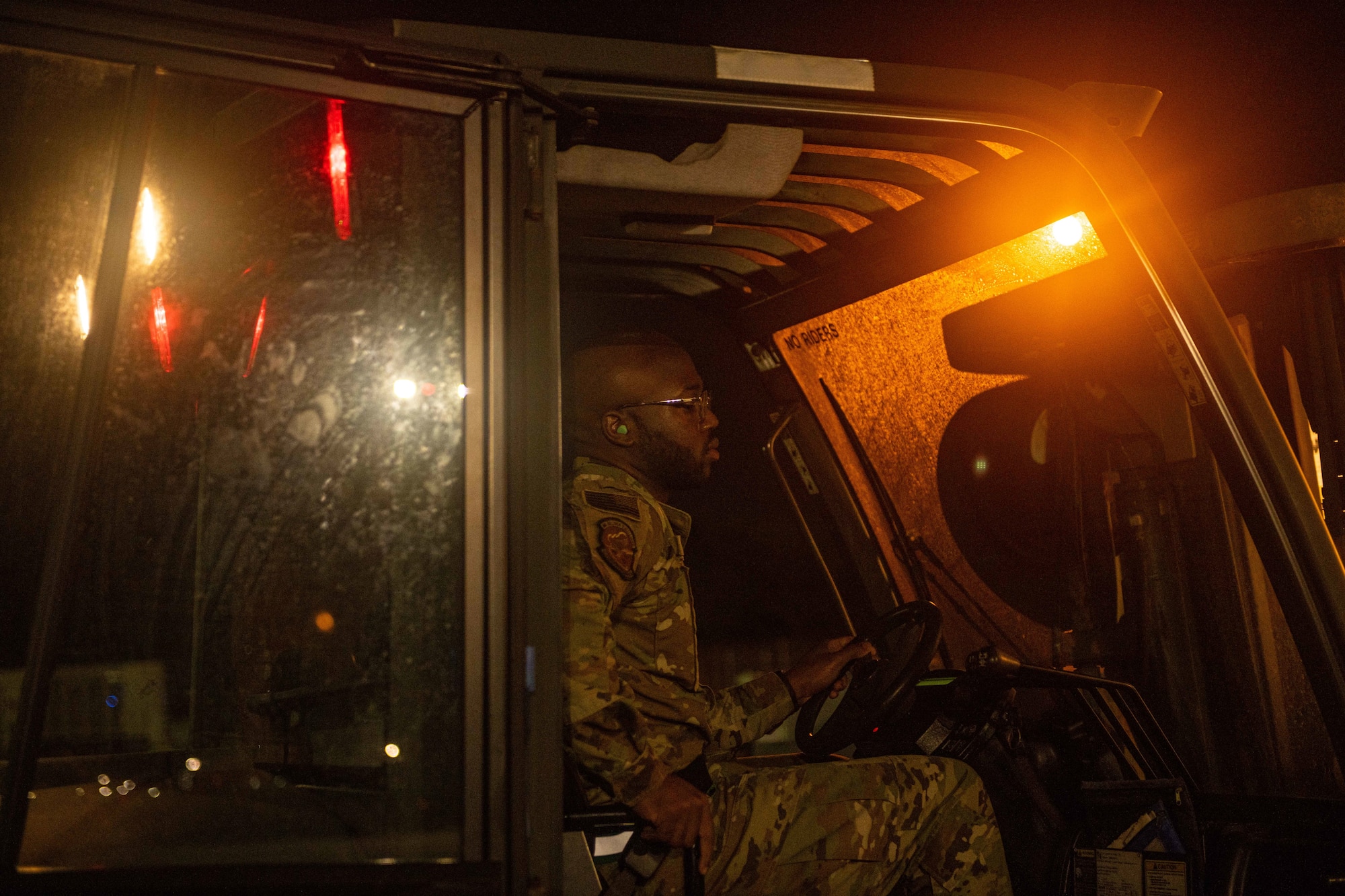 A side shot of an Airman driving a fork lift.