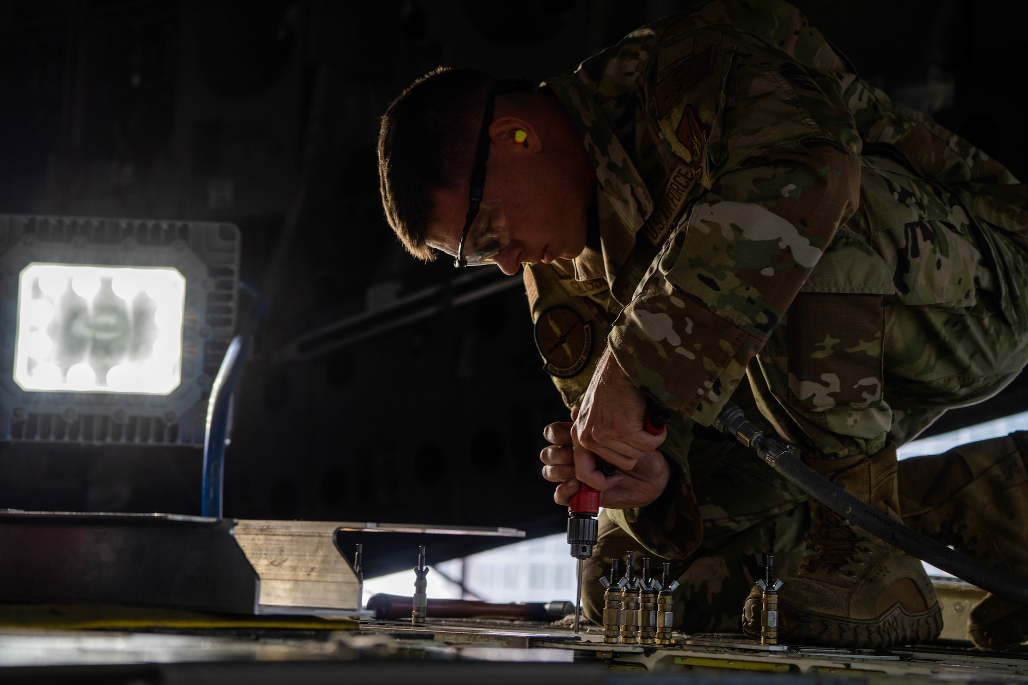 Senior Airman Tyler Glisson, 15th Maintenance Squadron aircraft structural maintenance journeyman repairs the ramp of a C-17 Globemaster III during a depot level repair at Joint Base Pearl Harbor-Hickam, Hawaii, Dec. 2, 2022. This process was performed for the first time at JBPHH and expedited the timeframe for accomplishing repairs by negating the need for a Depot Field Repair. (U.S. Air Force photo by Senior Airman Makensie Cooper)