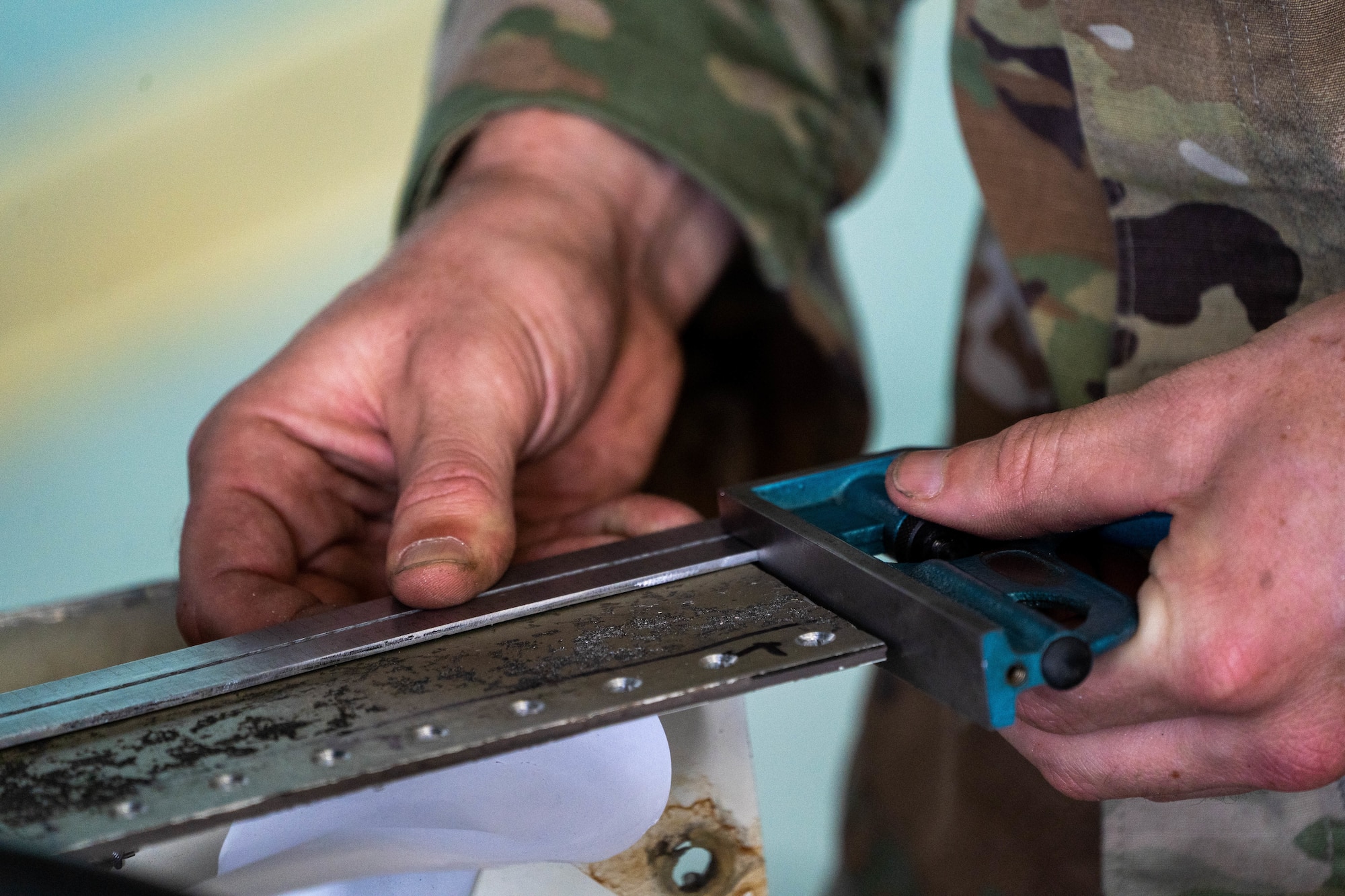 Senior Airman Tyler Glisson, 15th Maintenance Squadron aircraft structural maintenance journeyman, measures a bracket to repair a ramp of a C-17 Globemaster III during a depot level repair at Joint Base Pearl Harbor-Hickam, Hawaii, Dec. 2, 2022. This process was performed for the first time at JBPHH and expedited the maintenance timeframe by negating the need to send the aircraft to another location for repair. (U.S. Air Force photo by Senior Airman Makensie Cooper)