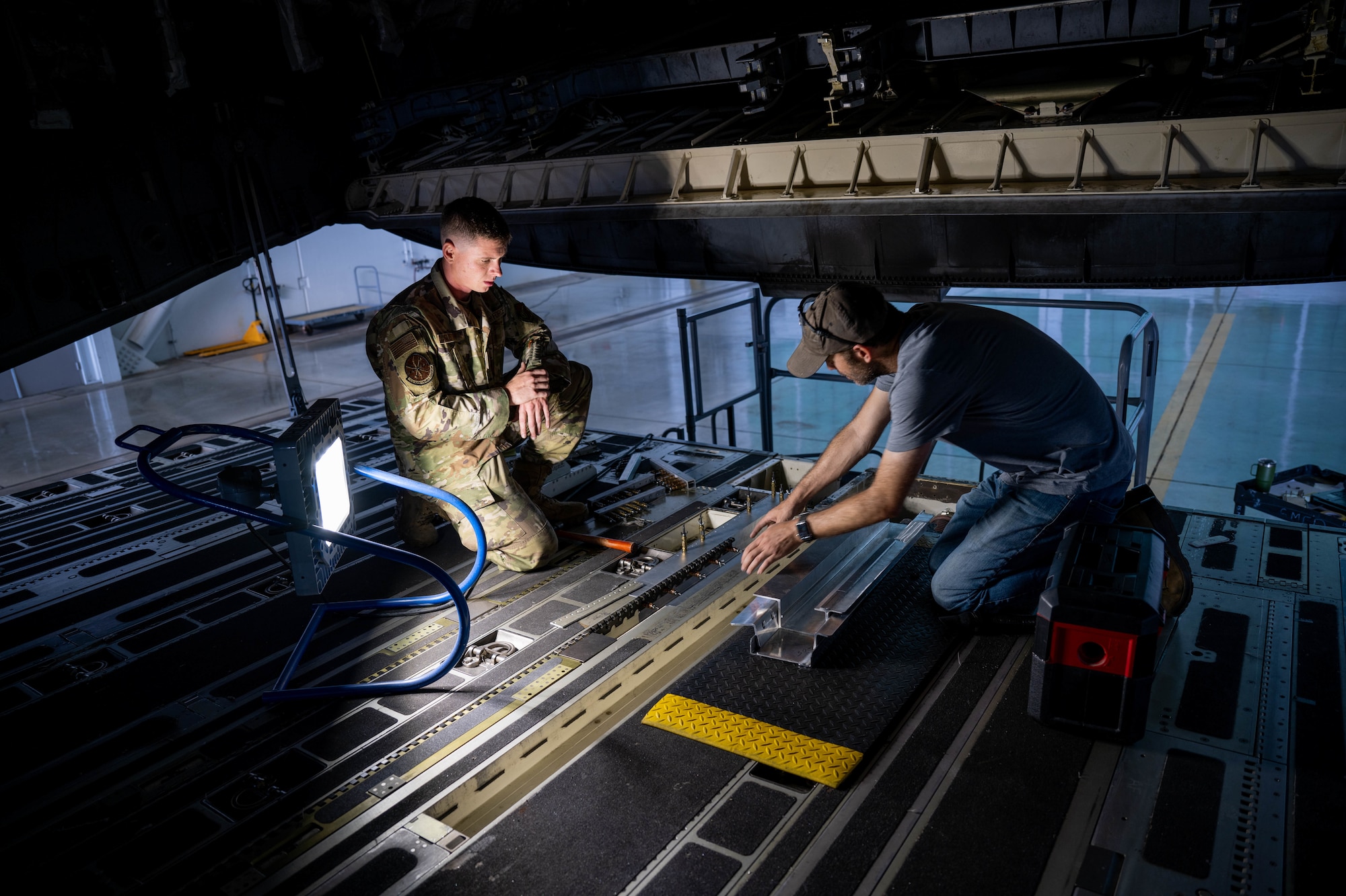 Darcy Morgan, 15th Maintenance Squadron aircraft structural maintenance craftsman, repairs the ramp of a C-17 Globemaster III during a depot level repair at Joint Base Pearl Harbor-Hickam, Hawaii, Dec. 2, 2022. The personnel built a replacement part from scratch to restore the structural integrity of the ramp and ensure the safety of the aircrew in flight. (U.S. Air Force photo by Senior Airman Makensie Cooper)