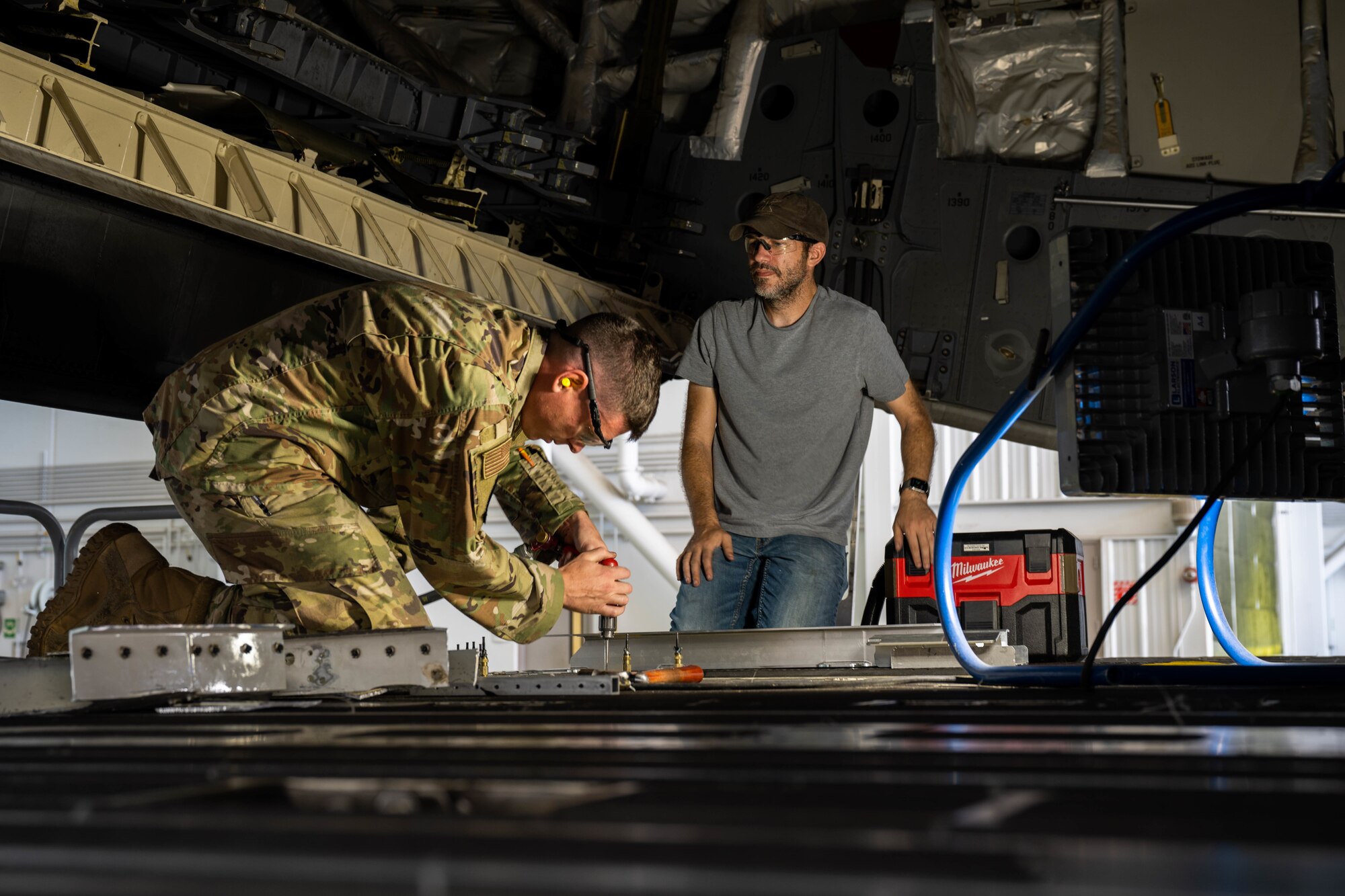 Senior Airman Tyler Glisson, 15th Maintenance Squadron aircraft structural maintenance journeyman, measures a bracket to repair the C-17 Globemaster III ramp during a depot level repair at Joint Base Pearl Harbor-Hickam, Hawaii, Dec. 2, 2022. Ensuring this repair is completed is essential to the safety and efficiency of loading cargo, conducting airdrops, and aeromedical evacuation missions. (U.S. Air Force photo by Senior Airman Makensie Cooper)