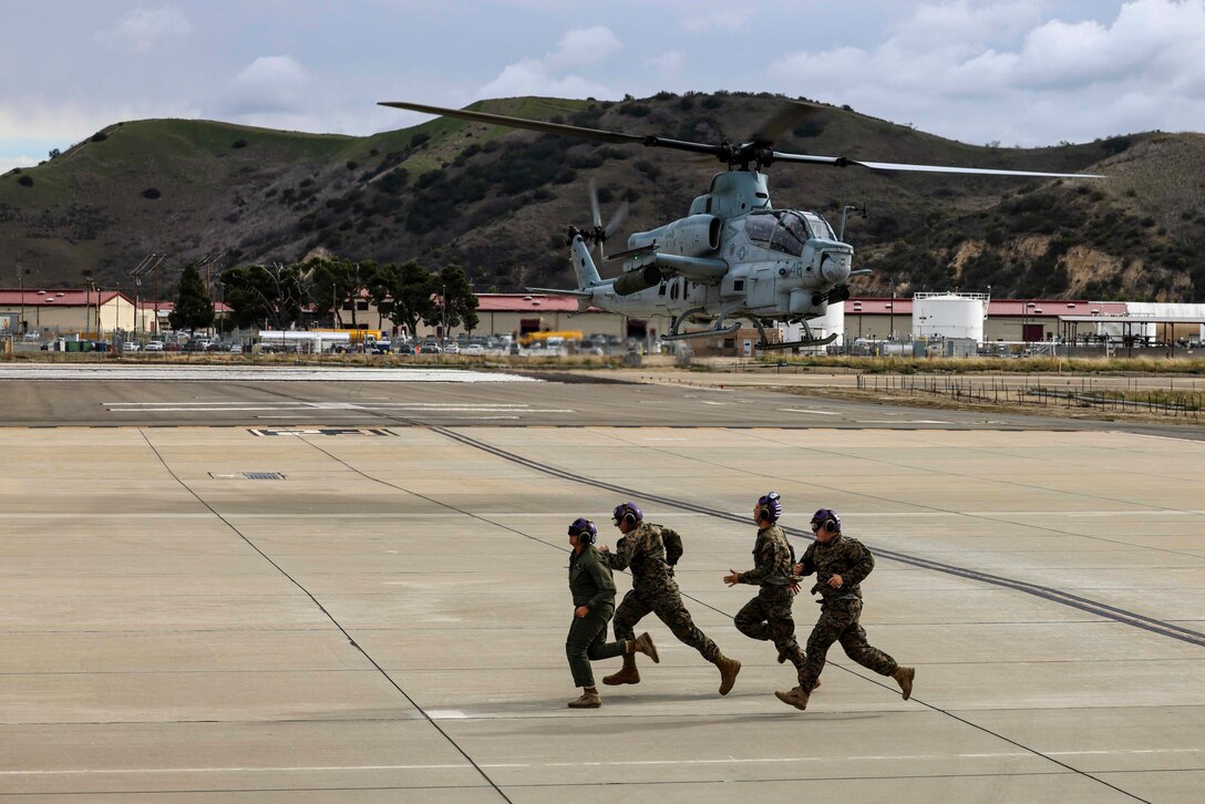U.S. Marines with Marine Light Attack Helicopter Squadron 369, Marine Aircraft Group 39, 3rd Marine Aircraft Wing, run to the refueling station during exercise Steel Knight 23, on Marine Corps Air Station Camp Pendleton, California, Dec. 6, 2022. Exercise Steel Knight provides 3rd MAW an opportunity to refine Wing-level warfighting in support of I Marine Expeditionary Force and fleet maneuver. (U.S. Marine Corps photo by Sgt. Fletcher)