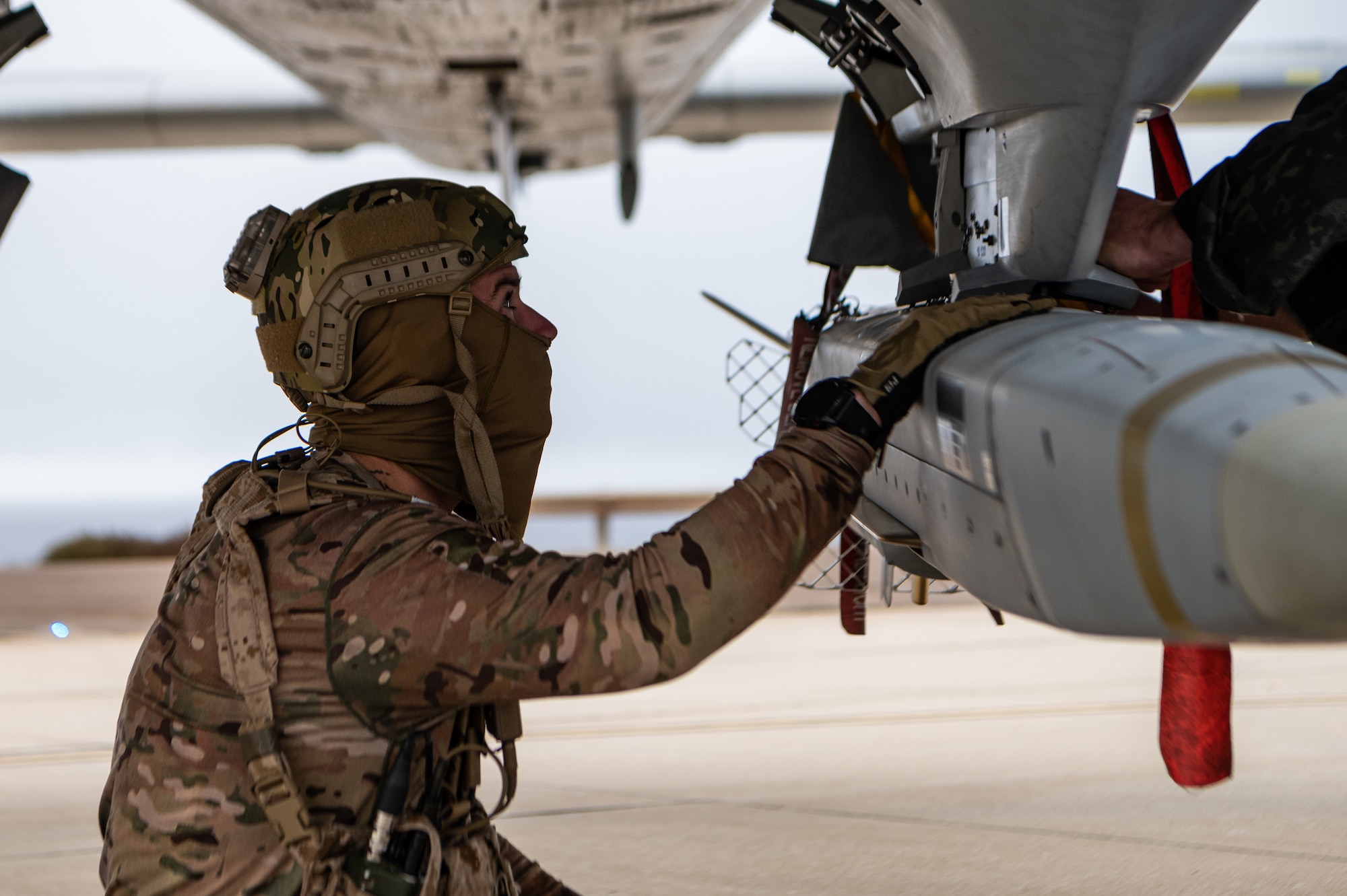 A Naval Special Warfare operator inspects a DATM-160 Miniature Air-Launched Decoy (MALD) on an A-10 Thunderbolt