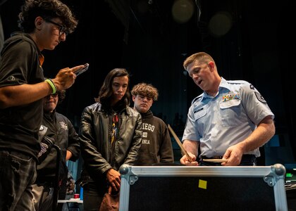 U.S. Air Force Tech. Sgt. Daniel Dowling, drummer for The U.S. Air Force Band, teaches a group of students how to play a riff at Southwest High School in El Centro, California, Nov. 15, 2022. The band held a mentoring session with the students and gave them the opportunity to ask questions about music and the military. (U.S. Air Force photo by Airman Bill Guilliam)