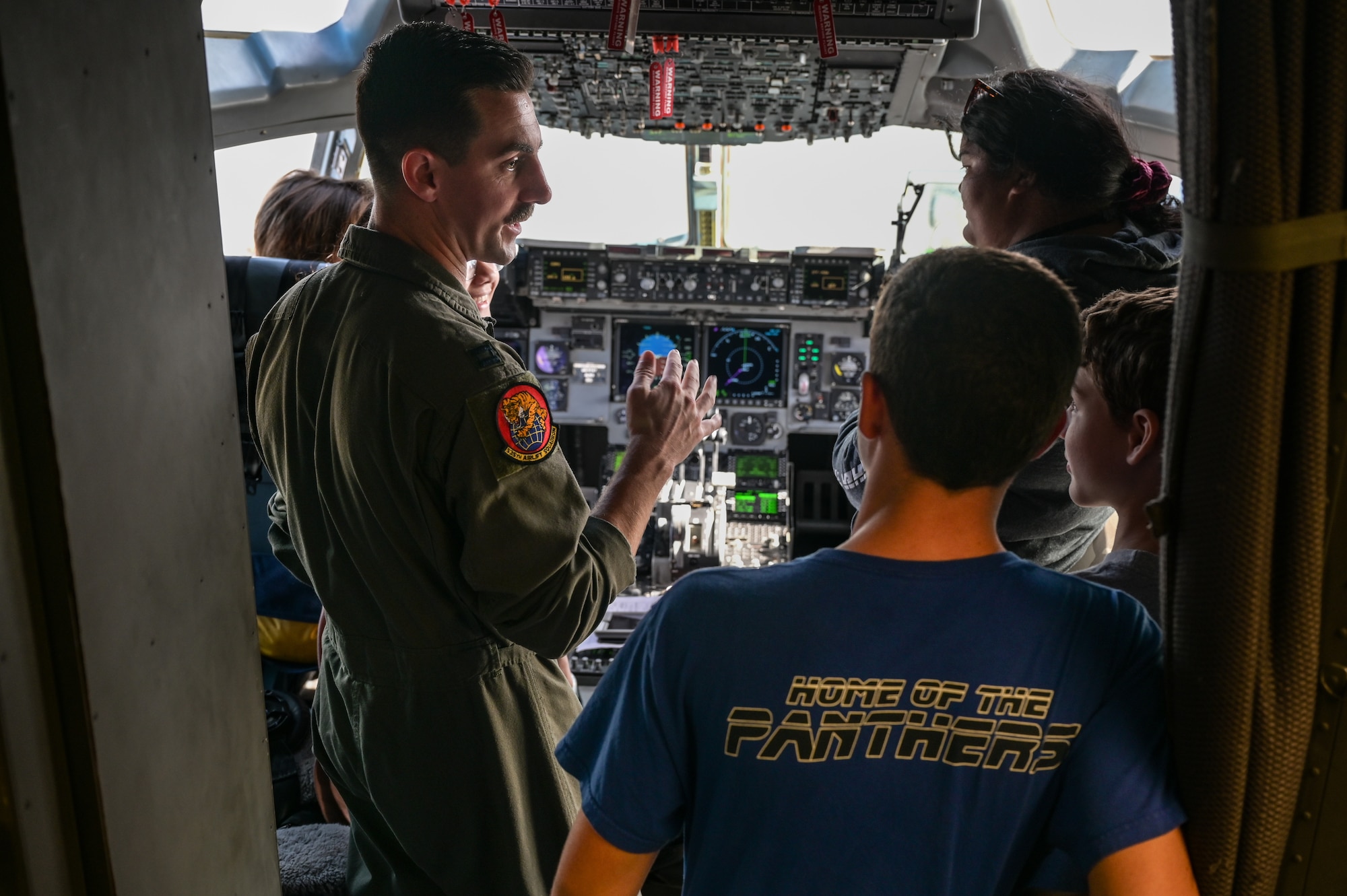 Capt. Keegan Reynolds, 535th Airlift Squadron C-17 Globemaster III pilot, speaks to students from Aliamanu Middle School about the flight deck of a C-17 during a base tour at Joint Base Pearl Harbor-Hickam, Hawaii, Nov. 22, 2022. Loadmasters, pilots and maintainers shared how they support the same mission, but in their own ways. (U.S. Air Force photo by Staff Sgt. Alan Ricker)