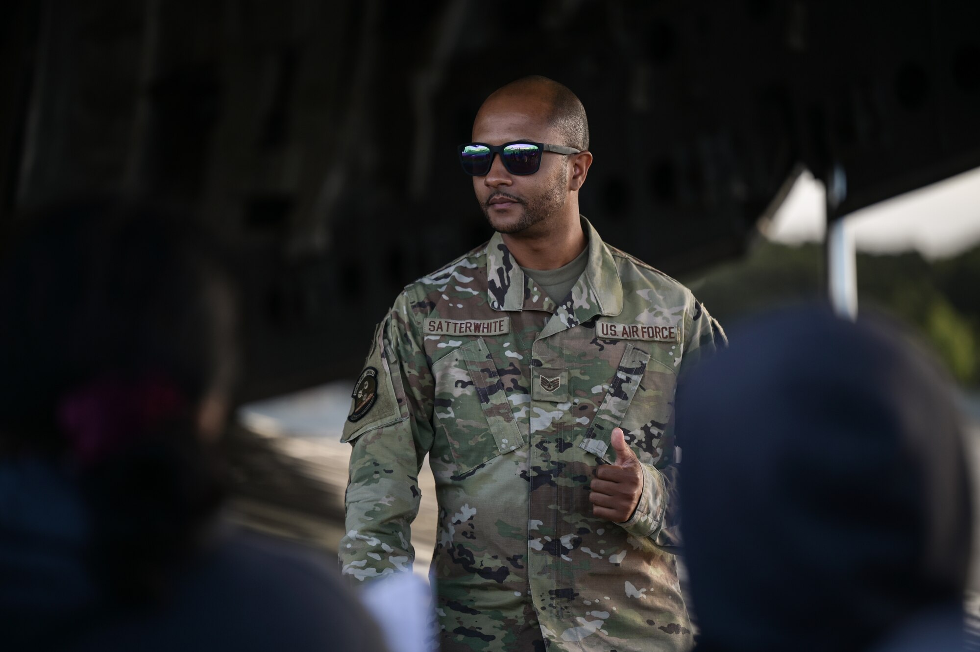 Staff Sgt. Milton Satterwhite, 735th Air Mobility Squadron C-5 Galaxy crew chief, introduces 535th Airlift Squadron and 15th Aircraft Maintenance Squadron personnel to students from Aliamanu Middle School during a base tour at Joint Base Pearl Harbor-Hickam, Hawaii, Nov. 22, 2022. Over 30 students visited a C-17 and F-22 Raptor static display, learning their mission operations and capabilities. (U.S. Air Force photo by Staff Sgt. Alan Ricker)