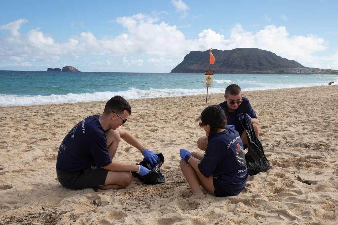 Participants with the Young Marine program collect debris during a base-wide beach clean-up, Marine Corps Base Hawaii, Dec. 2, 2022. The Young Marines participated in a base-wide beach clean-up as well as several other committee events, while participating and attending commemoration ceremonies of the 81st anniversary of the attacks on Pearl Harbor. (U.S. Marine Corps photo by Lance Cpl. Chandler Stacy)