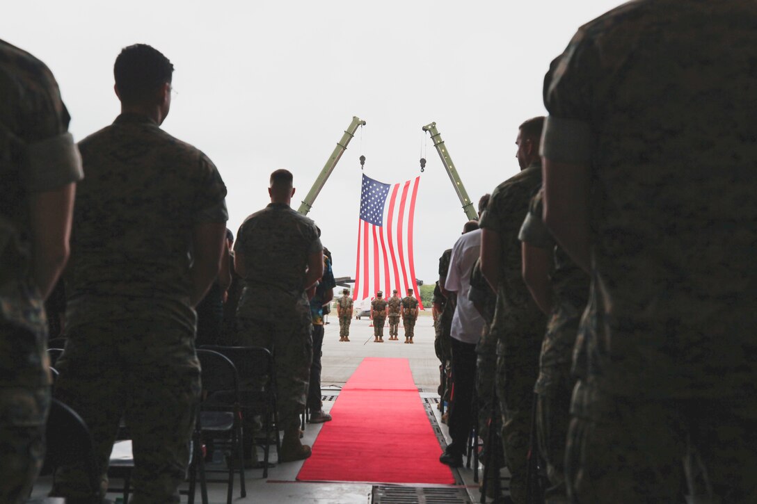 U.S. Marines and attendees stand for the national anthem during a change of command ceremony for Marine Medium Tiltrotor Squadron 268, Marine Aircraft Group 24,  Marine Aircraft Group 24, aboard Marine Corps Air Station Kaneohe Bay, Marine Corps Base Hawaii, Dec. 8, 2022. Lt. Col. Vanessa Clark relinquished command of VMM-268 to Lt. Col. Brandon Pope. (U.S. Marine Corps photo by Cpl. Brandon Aultman)