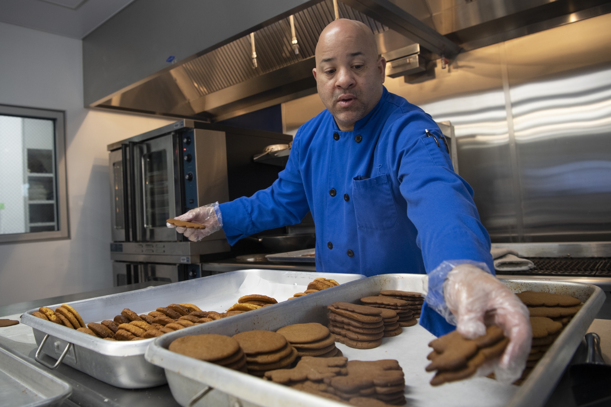 Barry Oxendine, Yokota High School culinary arts teacher, sorts cookies onto trays in preparation for the base’s annual Yokota Cookie Crunch at the Yokota High School located at Yokota Air Base, Japan, Dec. 8, 2022. Over the years, the cookie crunch became an annual event with participants including the Yokota High School, Yokota High School, United Service Organizations and more. This year more than 7,000 cookies have been pledged to the event by members across Yokota. (U.S. Air Force photo by Tech. Sgt. Christopher Hubenthal)