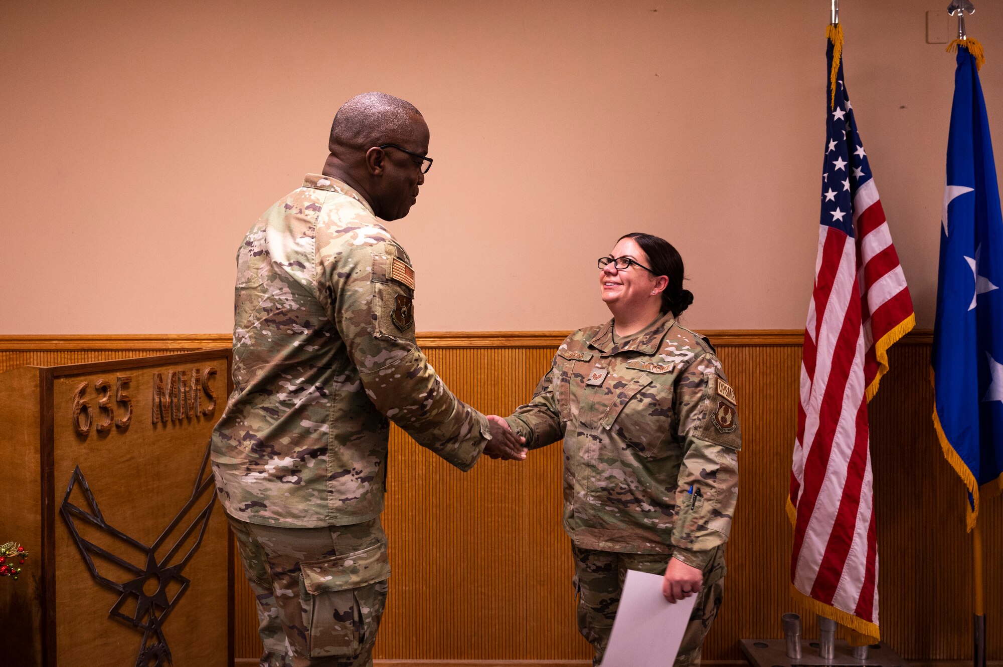 U.S. Air Force Lt. Gen. Stacey Hawkins, Air Force Sustainment Center commander, coins U.S. Air Force Staff Sgt. Kimberlie Cardona, 635th Materiel Maintenance Group operations manager at Holloman Air Force Base, New Mexico, Dec. 6, 2022. The 635th MMG is charged with maintaining accountability, storage, repair and inspection of Air Force Materiel Command and Air Combat Command assets in order to ensure their readiness for an operations downrange. (U.S. Air Force photo by Airman 1st Class Isaiah Pedrazzini)