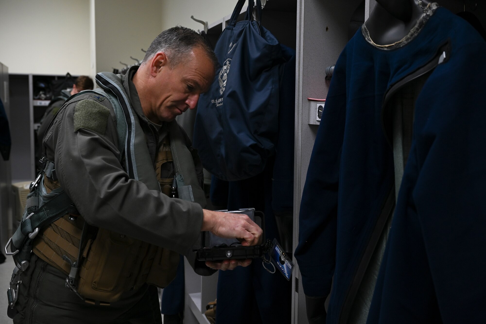 Lt. Gen. Scott L. Pleus, 7th Air Force commander, pulls a pair of attenuating custom communications earpiece system (ACCES) ear plugs out of a case at Kunsan Air Base, Republic of Korea, Dec. 8, 2022. The ACCES ear plugs help pilots listen to the radios in the F-16 Fighting Falcon while blocking out the noise from the jet engine. (U.S. Air Force photo by Senior Airman Akeem K. Campbell)