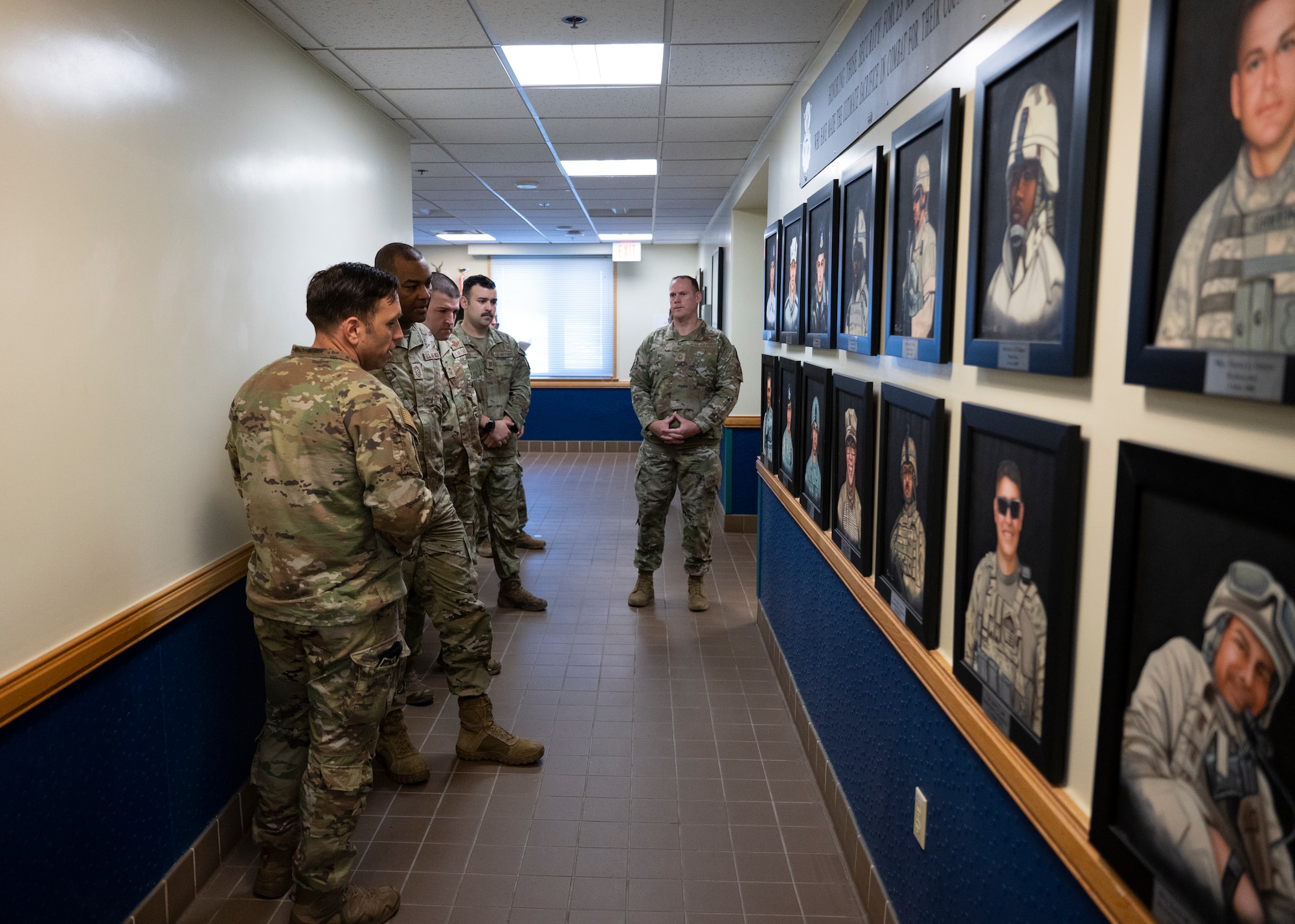 Lt. Col. Jesse Goens, 8th Security forces Squadron commander (first from left), and Chief Master Sgt. Alvin Dyer, 7th Air Force command chief (second from left), view a memorial wall of fallen security forces Airmen during a 7th AF leadership team visit at Kunsan Air Base, Republic of Korea, Dec. 8, 2022. During his portion of the visit, Dyer met with select squadrons, engaged with Airmen and received hands-on instruction in use of force simulations. (U.S. Air Force photo by Staff Sgt. Isaiah J. Soliz)
