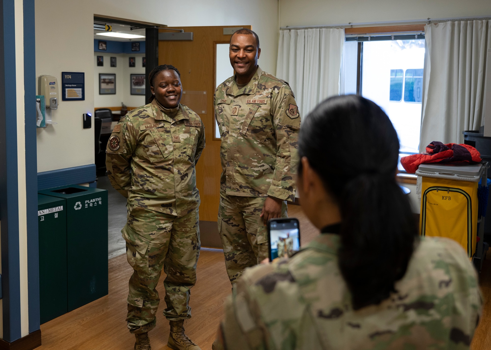 Staff Sgt. Aslee McElroy, 8th Medical Group physical evaluation board liaison officer (left), and Chief Master Sgt. Alvin R. Dyer, 7th Air Force command chief (center), pose for a photo taken by Lt. Col. Elisa Hammer, 8th Operational Medical Readiness Squadron commander (right), during a 7th AF leadership visit to Kunsan Air Base, Republic of Korea, Dec. 8, 2022. Leadership from 7th AF visited Kunsan to meet with Airmen, see recent changes and recognize outstanding performers. (U.S. Air Force photo by Staff Sgt. Isaiah J. Soliz)
