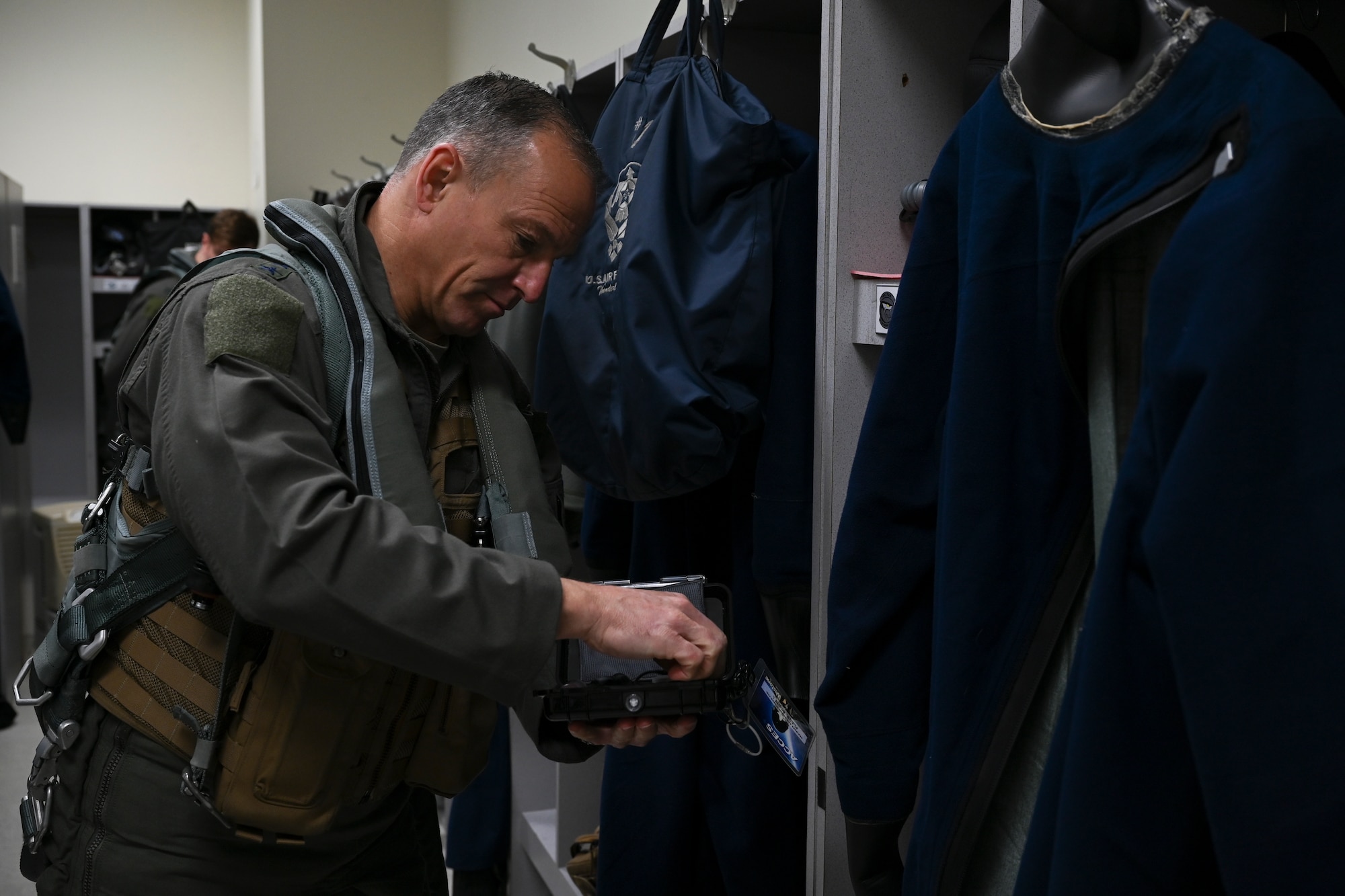 Lt. Gen. Scott L. Pleus, 7th Air Force commander, pulls a pair of attenuating custom communications earpiece system (ACCES) ear plugs out of a case at Kunsan Air Base, Republic of Korea, Dec. 8, 2022. The ACCES ear plugs help pilots listen to the radios in the F-16 Fighting Falcon while blocking out the noise from the jet engine. (U.S. Air Force photo by Senior Airman Akeem K. Campbell)