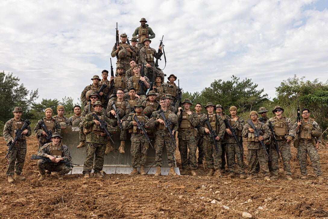 U.S. Marine Corps combat engineers with 3rd Landing Support Battalion, Combat Logistics Regiment 3, 3rd Marine Logistics Group, pose for a group photo during exercise Winter Workhorse, at Central Training Area, Camp Hansen, Okinawa, Japan, Dec. 6, 2022. Winter Workhorse is an annual exercise for CLR-3 to train to carry out mission essential tasks in forward-deployed, austere environments. (U.S. Marine Corps photo by Lance Cpl. Weston Brown)