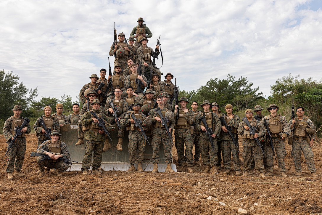 U.S. Marine Corps combat engineers with 3rd Landing Support Battalion, Combat Logistics Regiment 3, 3rd Marine Logistics Group, pose for a group photo during exercise Winter Workhorse, at Central Training Area, Camp Hansen, Okinawa, Japan, Dec. 6, 2022. Winter Workhorse is an annual exercise for CLR-3 to train to carry out mission essential tasks in forward-deployed, austere environments. (U.S. Marine Corps photo by Lance Cpl. Weston Brown)