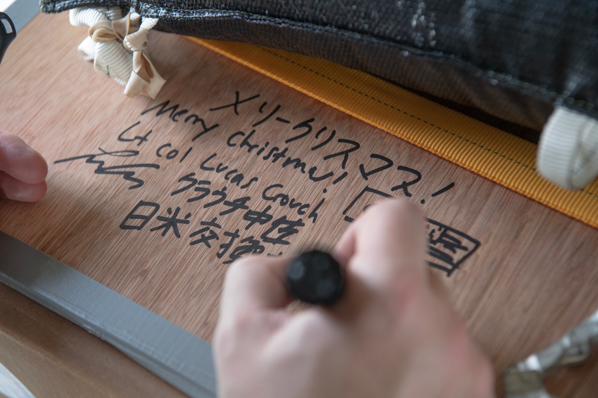 A U.S. Air Force pilot writes a message on a bundle
