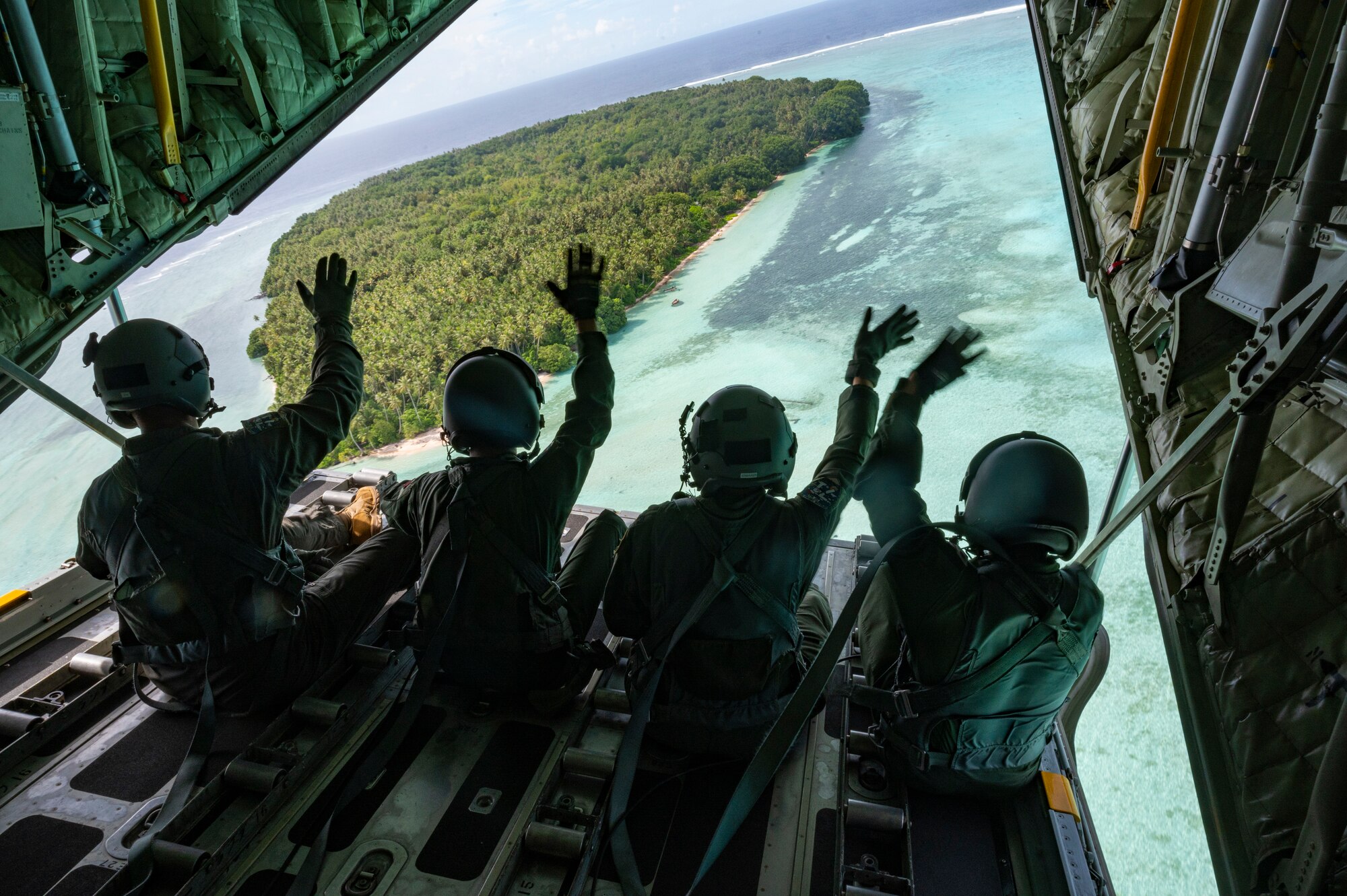 Members of the U.S. Forces Japan wave from the ramp of a C-130H Hercules