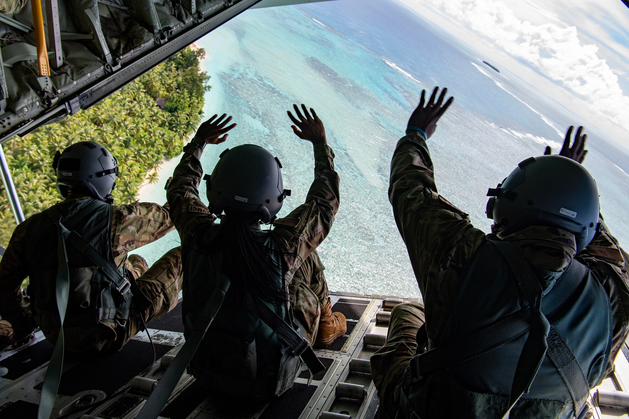 Airmen with the 36th Expeditionary Airlift Squadron wave to the island community