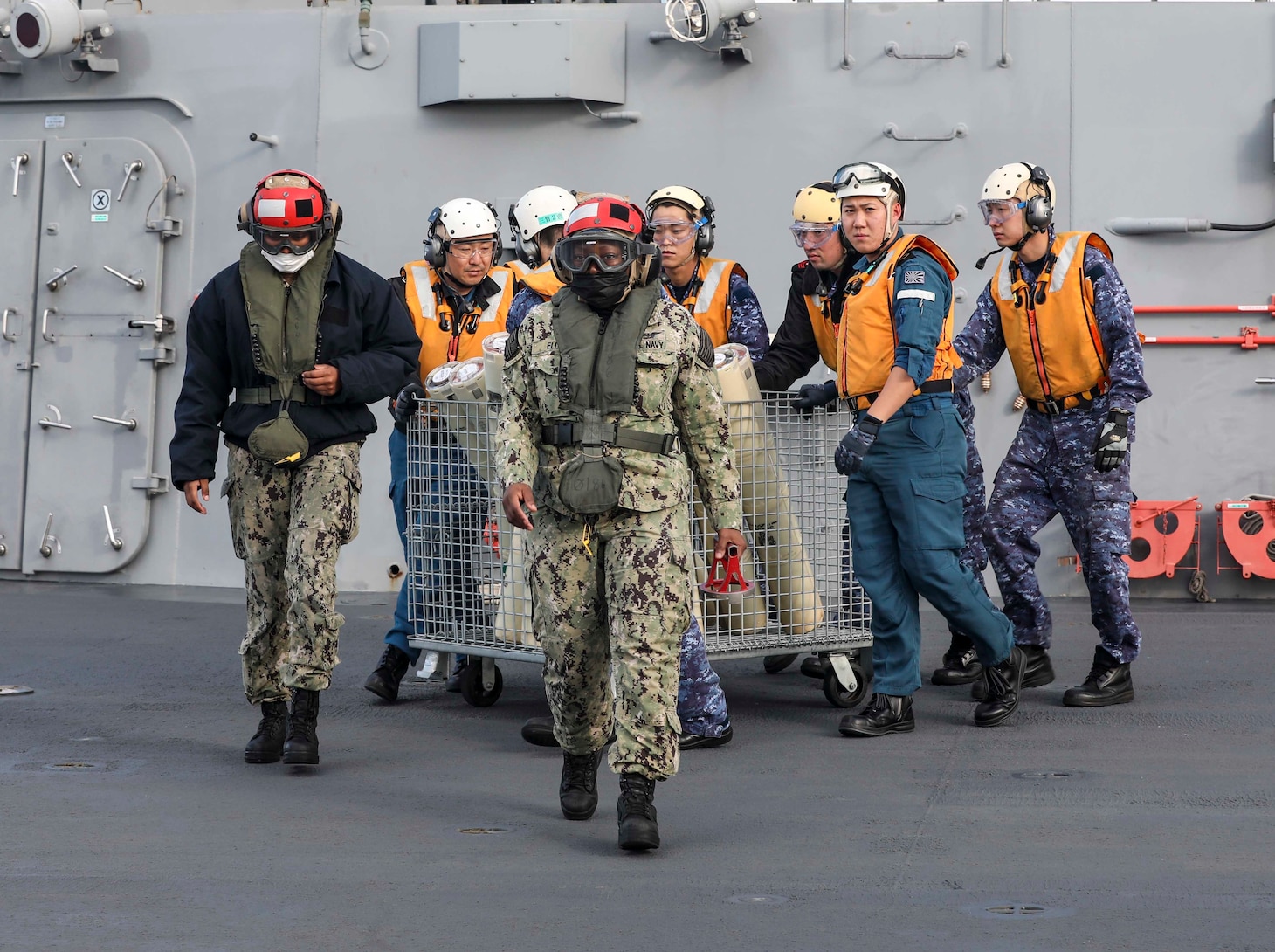 PHILIPPINE SEA (Dec. 6, 2022) Aviation Ordnanceman 2nd Class Elouise Ellis, Aviation Ordnanceman Airman Tymira Holland and Japan Maritime Self-Defense Force (JMSDF) sailors load sonobuoys into an MH-60R Sea Hawk helicopter assigned to the “Warlords” of Helicopter Maritime Strike Squadron (HSM) 51 aboard the multi-purpose destroyer JS Izumo (DDH 183) during a bi-lateral anti-submarine warfare (ASW) exercise, Dec. 6. The U.S. Navy and JMSDF regularly fly, sail and operate together with other Allies and partners to promote security and stability throughout the region. (U.S. Navy photo by Mass Communication Specialist 1st Class Deanna C. Gonzales)