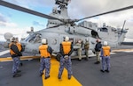 PHILIPPINE SEA (Dec. 6, 2022) Naval Air Crewman (Helicopter) 2nd Class Maxwell Bohnert and Aviation Ordnanceman 2nd Class Elouise Ellis, load and inspect sonobuoys in an MH-60R Sea Hawk helicopter assigned to the “Warlords” of Helicopter Maritime Strike Squadron (HSM) 51 aboard the Japan Maritime Self-Defense Force (JMSDF) multi-purpose destroyer JS Izumo (DDH 183) during a bi-lateral anti-submarine warfare (ASW) exercise, Dec. 6. The U.S. Navy and JMSDF regularly fly, sail and operate together with other Allies and partners to promote security and stability throughout the region. (U.S. Navy photo by Mass Communication Specialist 1st Class Deanna C. Gonzales)