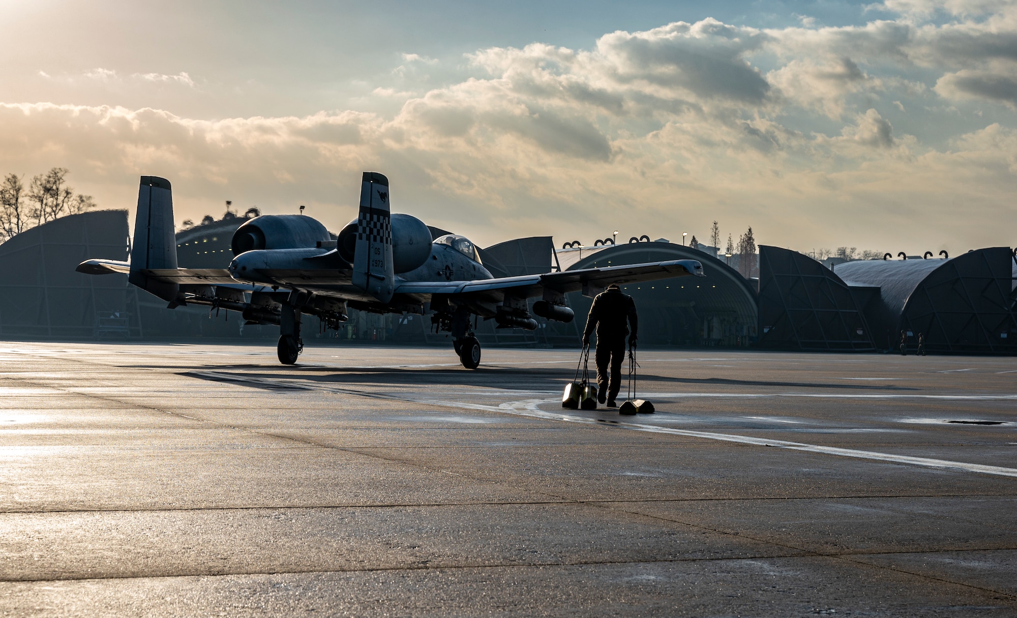 U.S. Air Force Senior Airman Erick Ore, 25th Fighter Generation Squadron crew chief, pulls chalks towards an A-10C Thunderbolt II on the flightline at Osan Air Base, Republic of Korea, Dec. 7, 2022.