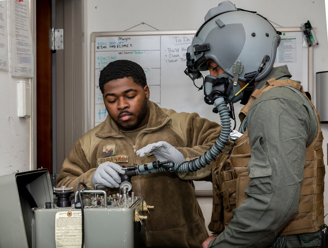 U.S. Air Force Senior Airman Vincent Eubanks, 51st Operations Support Squadron aircrew flight equipment (AFE) journeyman, demonstrates an oxygen mask fitting on Staff Sgt. Mathew Wilson, 51st OSS AFE shift lead, at Osan Air Base, Republic of Korea, Dec. 7, 2022.