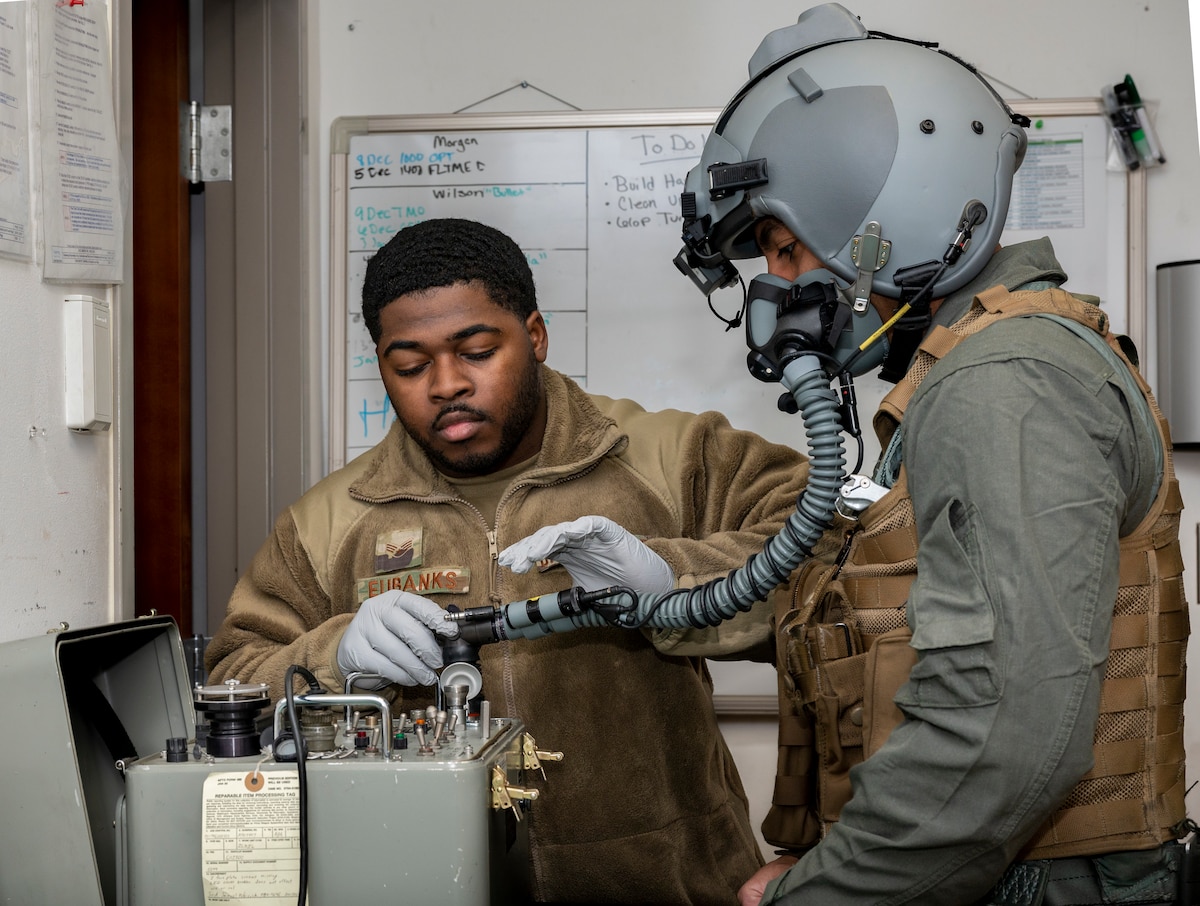 U.S. Air Force Senior Airman Vincent Eubanks, 51st Operations Support Squadron aircrew flight equipment (AFE) journeyman, demonstrates an oxygen mask fitting on Staff Sgt. Mathew Wilson, 51st OSS AFE shift lead, at Osan Air Base, Republic of Korea, Dec. 7, 2022.