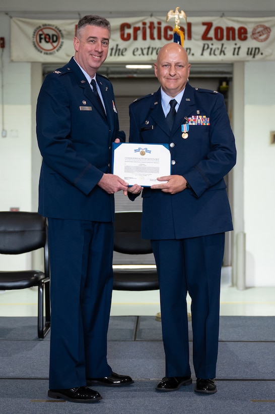 Col. Bruce Bancroft, left, commander of the 123rd Airlift Wing, presents Col. Michael A. Cooper, outgoing commander of the 123rd Medical Group, with a Kentucky Distinguished Service Medal during Cooper's retirement ceremony at the Kentucky Air National Guard Base in Louisville, Ky., Sept. 11, 2022. Cooper served for 30 years in the Kentucky Army National Guard, Air Force Reserve and Kentucky Air National Guard. (U.S. Air National Guard photo by Dale Greer)