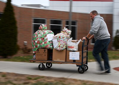 Man pushing cart full of wrapped presents