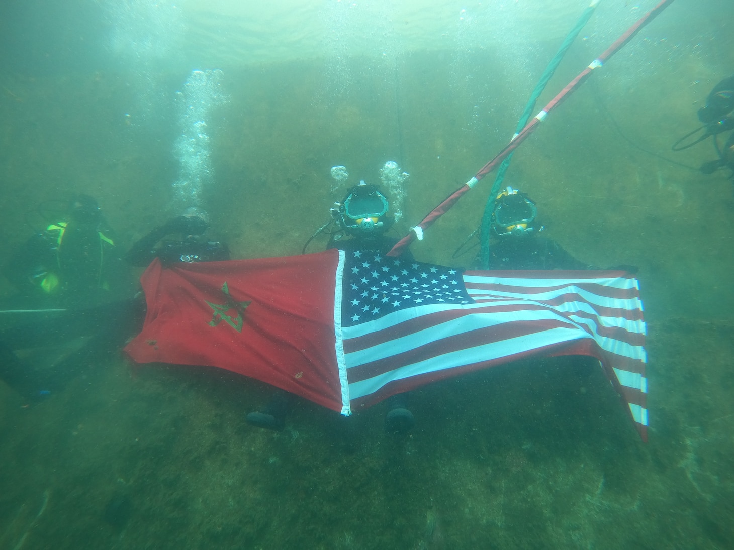 Navy divers from the Royal Moroccan Navy and the U.S. Navy’s Underwater Construction Team 1 present their national colors underwater during bilateral diving operations in Ksar Sghir, Morocco, Nov. 23, 2022.