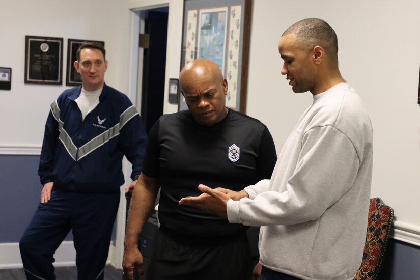 Senior Enlisted Advisor Tony Whitehead (center) visited cadets of the University of Kentucky Reserve Officer Training Corps and received an AFROTC DET 290 Flying Wildcats coin from Master Sgt. Tico Jones (right), personnel noncommissioned officer in charge, on behalf of Maj. Jeremy Morris (left), operations officer, while touring Buell Armory in Lexington, Ky. on Dec. 5, 2022. (U.S. Army photo by Lt. Col. Carla Raisler)
