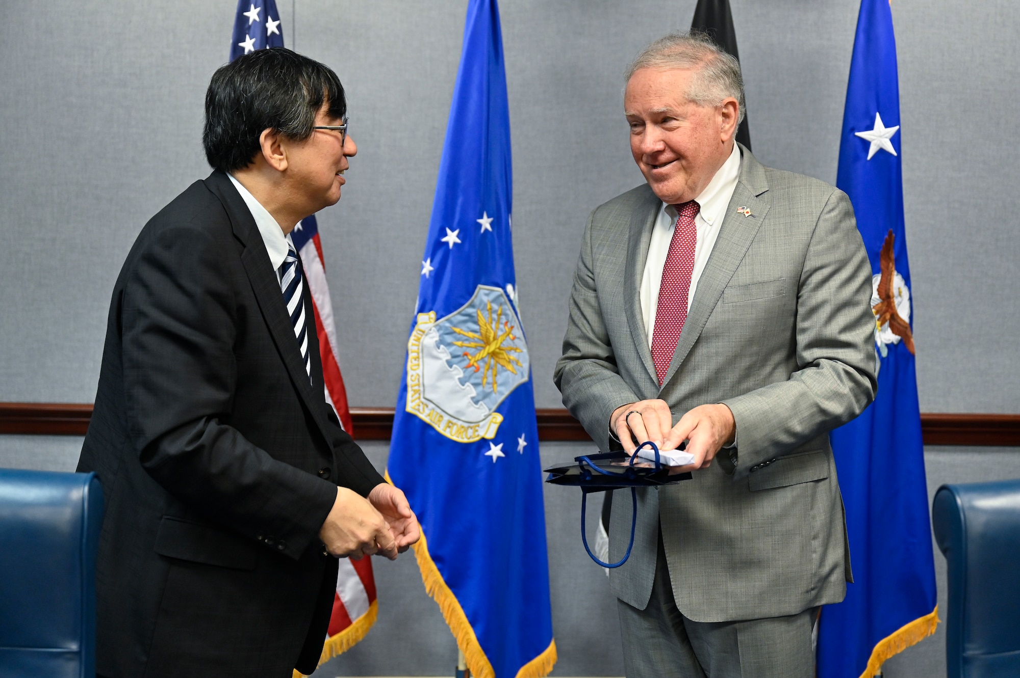 Secretary of the Air Force Frank Kendall, right, exchanges gifts with Hideki Tsuchimoto, commissioner of the Acquisition, Technology and Logistics Agency.