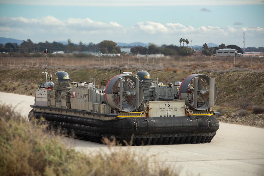 A U.S. Navy landing craft, air cushion with Assault Craft Unit 5, Naval Beach Group 5, taxies down a runway during exercise Steel Knight 23 at White Beach, Camp Pendleton, California, Dec. 6, 2022. ACU-5 and Marine Air Control Group 38 demonstrated the ability to use amphibious connectors to quickly reposition aviation command and control Marines and equipment in a littoral environment. Exercise Steel Knight 23 provides 3rd Marine Aircraft Wing an opportunity to refine Wing-level warfighting in support of I Marine Expeditionary Force and fleet maneuver. (U.S. Marine Corps photo by Lance Cpl. Childs)