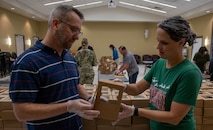 Jason Bateman, president of the Team Charleston Key Spouses Club, left, and Adrienne Lankford, a volunteer, place cookies and a letter into a box.