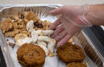 Jason Bateman, president of the Team Charleston Key Spouses Club, packages cookies.