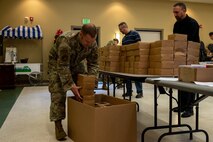 U.S. Air Force Master Sgt. John Plumley, 628th Logistics Readiness Squadron first sergeant, places boxes of holiday cookies into a box.