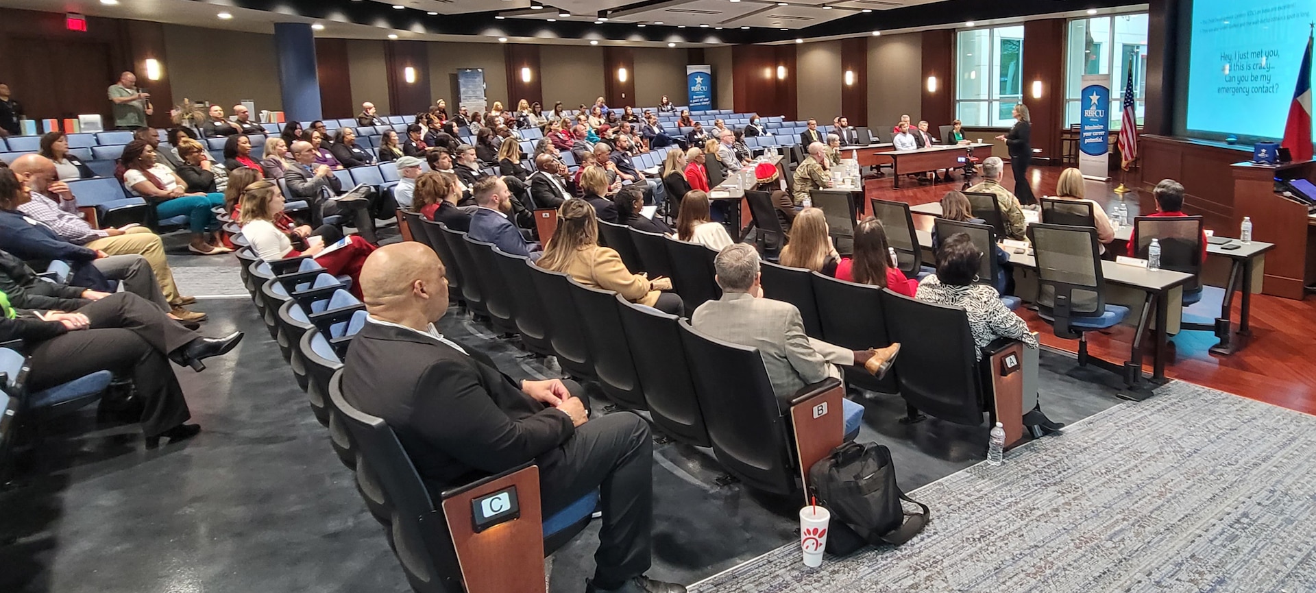 female speaker is briefing audience of 102 people