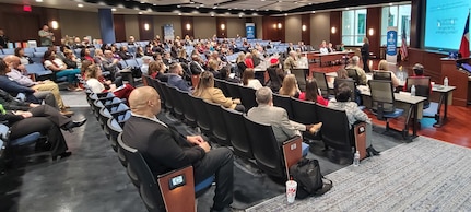 female speaker is briefing audience of 102 people