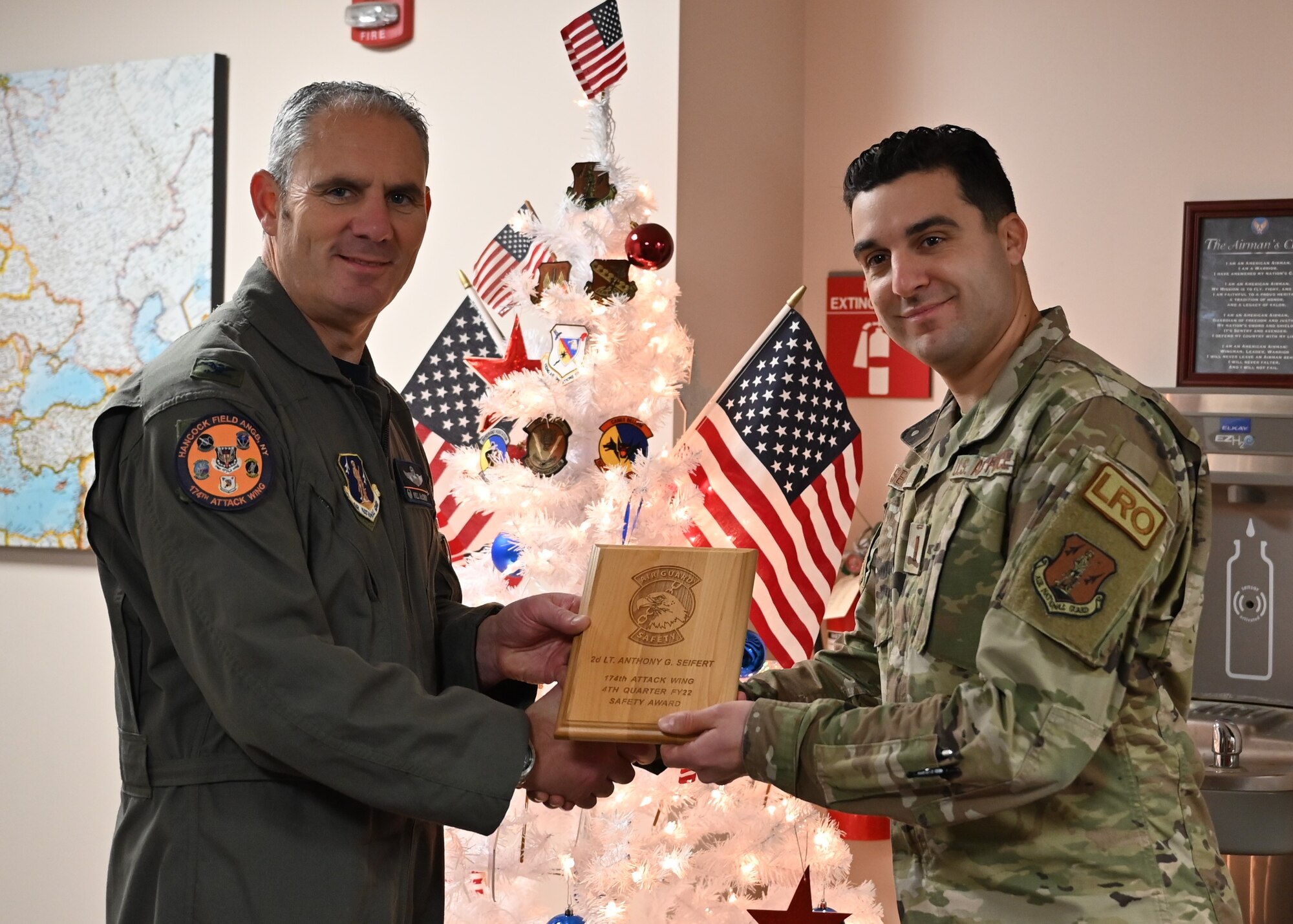 New York Air National Guard 2nd Lt. Anthony Seifert, a member of the 174th Attack Wing, receives the wing's Safety Award from Colonel William McCrink III, 174th Attack Wing commander, during a ceremony on Nov. 30, 2022. Seifert was recognized for his actions that helped to ensure an airman received proper medical attention that prevented long term negative effects for the airman. (U.S. Air National Guard photo by Master Sgt. Barbara Olney)