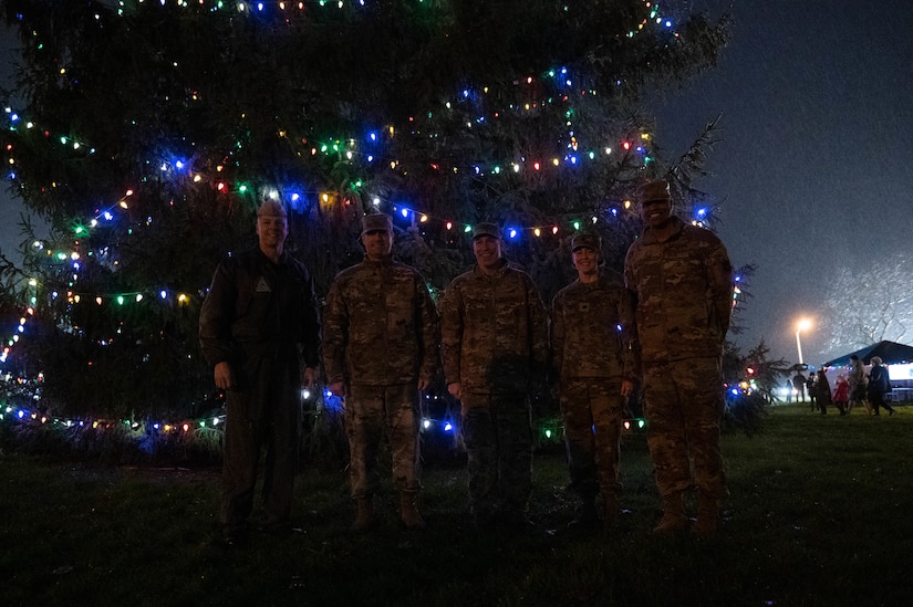Joint Base MDL leadership smiles for a group photo during the annual JB MDL holiday tree lighting ceremony on Joint Base McGuire-Dix-Lakehurst, N.J., Dec. 6, 2022. The annual JB MDL holiday tree lighting ceremony featured a variety of festivities, such as: horse-and-carriage rides, funnel cakes, pretzels, hot chocolate, and meeting in-person with Mr. and Mrs. Claus. The annual tree lighting ceremony is an opportunity for JB MDL families to come together at the start of the holiday season. (U.S. Air Force photo by Senior Airman Faith Iris MacIlvaine)