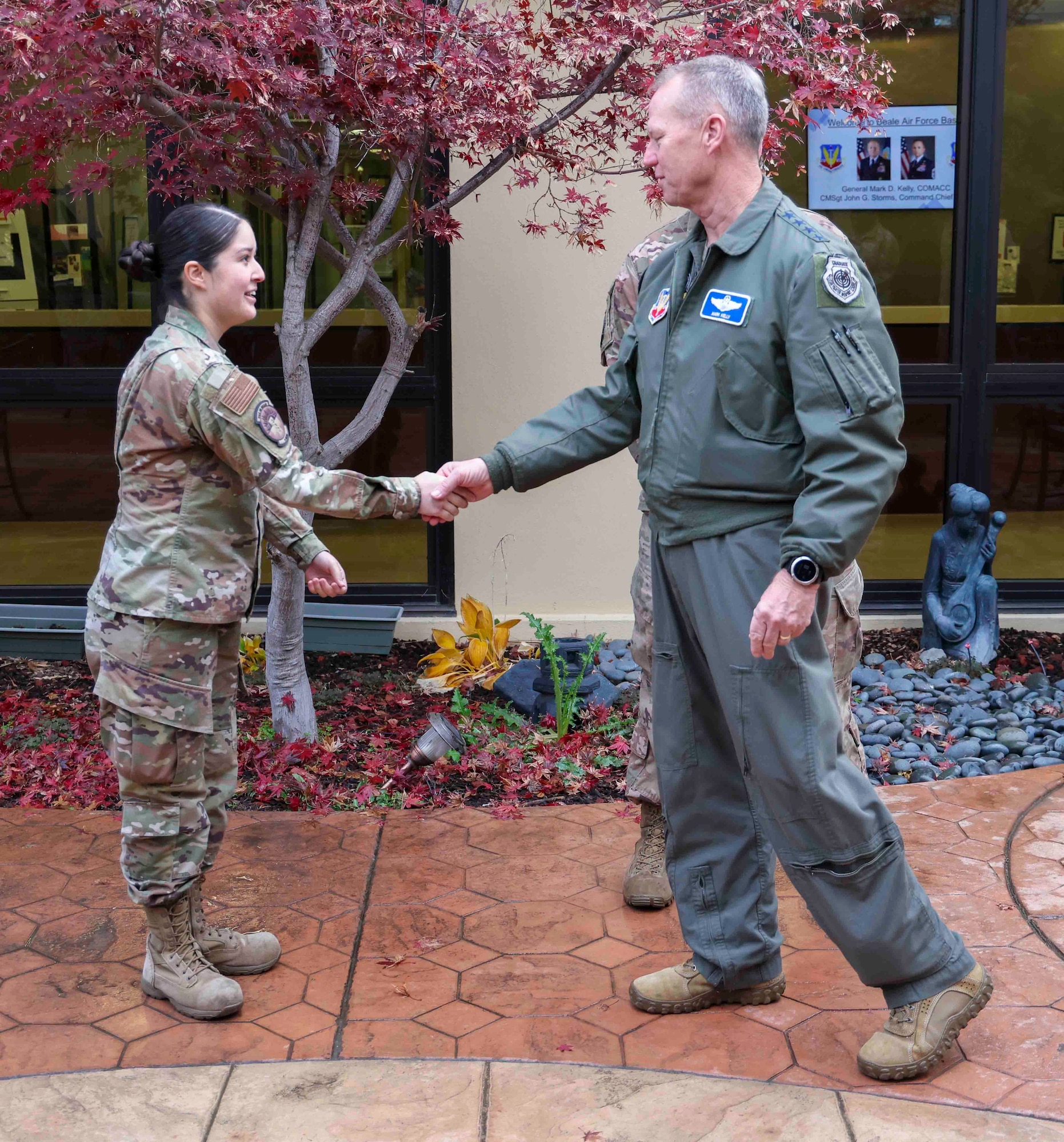 U.S Air Force Gen. Mark Kelly, commander of Air Combat Command, coins Senior Airman Brianna Ortega, 9th Medical Group, at Beale Air Force Base, Calif. on Dec. 6, 2022.
