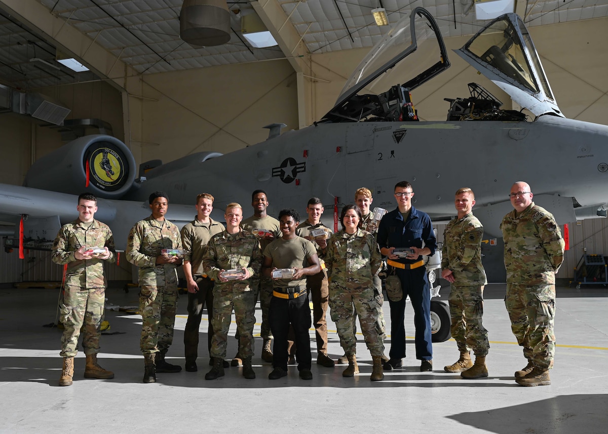 A photo of a group of people in military uniforms holding cookies.