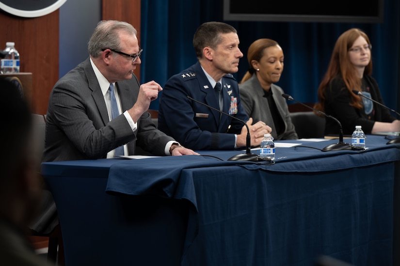 Four people sit at a table.