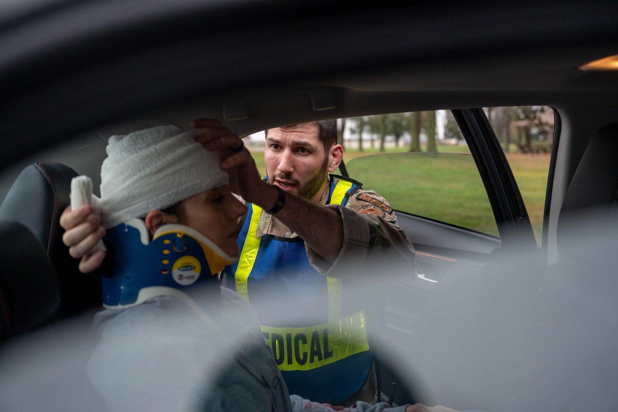 Staff Sgt. Max Robichaud, 436th Operational Medical Readiness Squadron ambulance response team member, assists a simulated car crash victim during an exercise at Dover Air Force Base, Delaware, Dec. 7, 2022. The three-day exercise tested the response capabilities of Team Dover through various scenarios in an effort to strengthen their ability to provide rapid-global mobility in challenging conditions. (U.S. Air Force photo by Senior Airman Faith Barron)